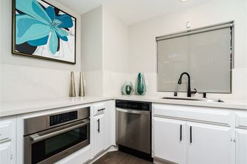 A kitchen with white cabinets and stainless steel appliances